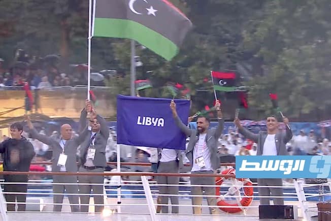أبوزريبة وملك مختار يحملان العلم الليبي خلال حفل افتتاح الأولمبياد