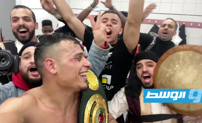 الزناد يحمل حزام النصر وسط الهتاف مع رجل الزي الليبي الحامل للطبلة